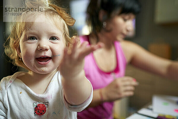 Glückliches  lächelndes  süßes kleines Mädchen  das in Richtung der Kamera zeigt