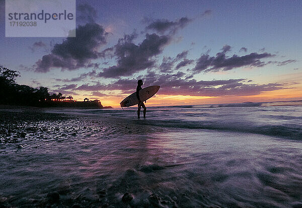 Surfer Girl Silhouette gegen bunte Sonnenuntergang