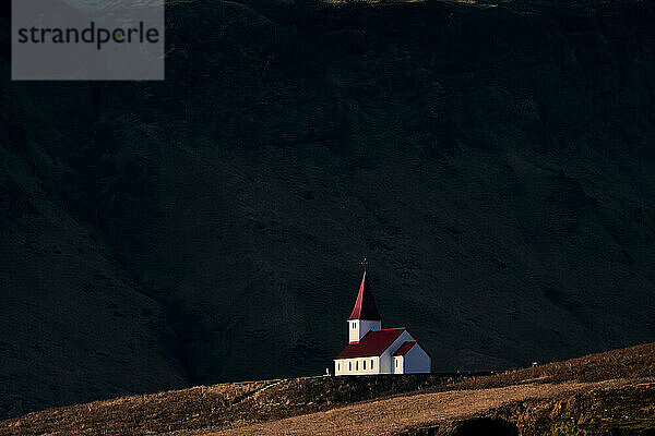 Kirche am dunklen Berghang