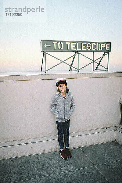 Junge steht unter einem Teleskopschild in Los Angeles
