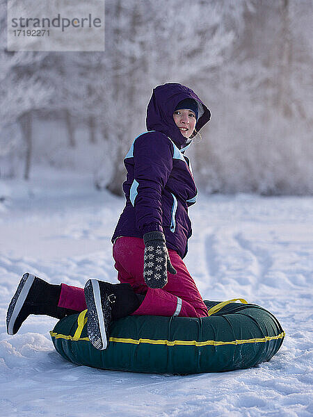 Lächelndes Teenager-Mädchen  das die Winteraktivitäten im Freien genießt