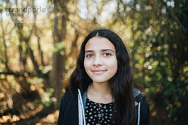 Außerhalb Porträt eines jungen Teenager-Mädchen mit einem süßen geschlossenen Mund Lächeln