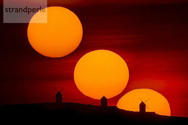 Sonnenuntergangssequenz mit Silhouette alter Windmühlen  Consuegra  Spanien