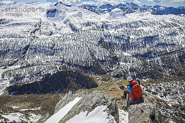 Ein Mann besteigt an einem sonnigen Tag einen verschneiten Berg in Devero  Italien.