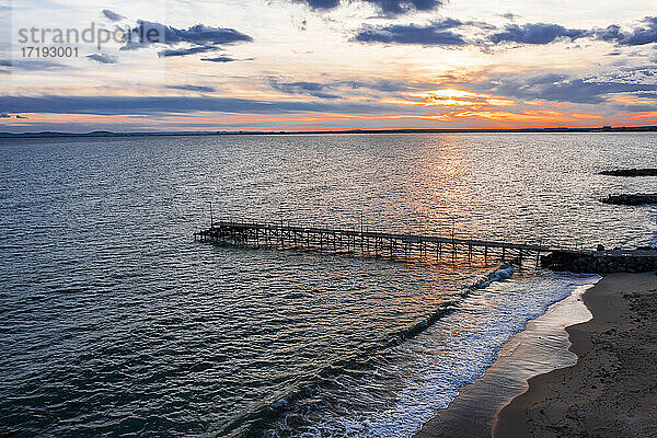 Luftaufnahme des Fischerstegs am Strand und schöner Sonnenuntergang