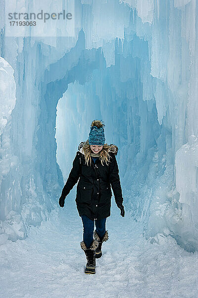 Lächelnde junge Frau beim Spaziergang in Eisschlössern