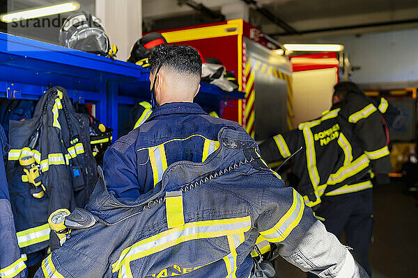 Feuerwehrmann  der sich für einen Einsatz umzieht