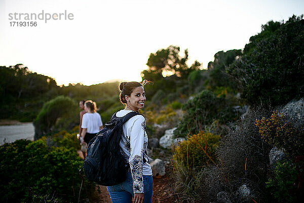 Glückliche junge Frau wandert mit Freunden auf Mallorca
