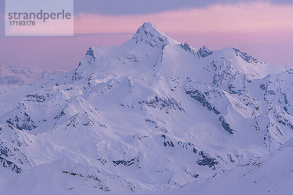 Idyllische Aufnahme eines schneebedeckten Berges bei Sonnenuntergang