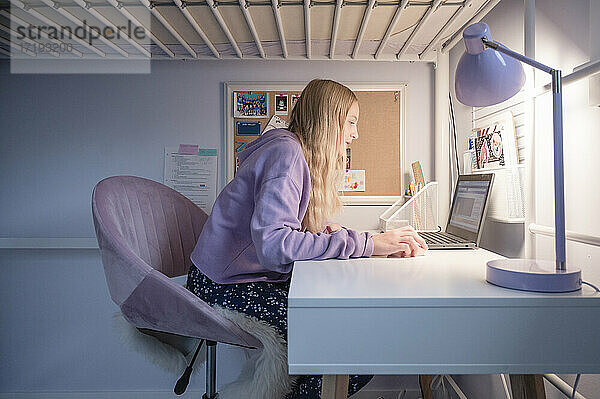 Tween Girl Sitting at Desk at Home Attending Remote School