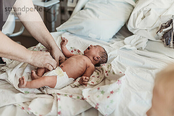 Vater bereitet seinen neugeborenen Sohn auf die Heimkehr vom Geburtshaus vor
