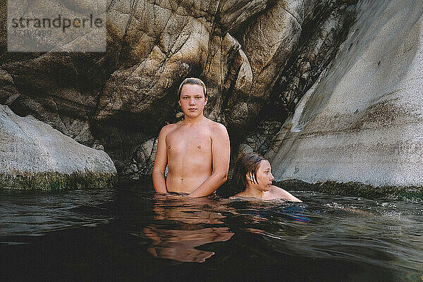 Zwei Freunde posieren im Wasser mit Granit-Canyon-Wand