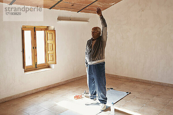 ein älterer Mann macht zu Hause Dehnungsübungen