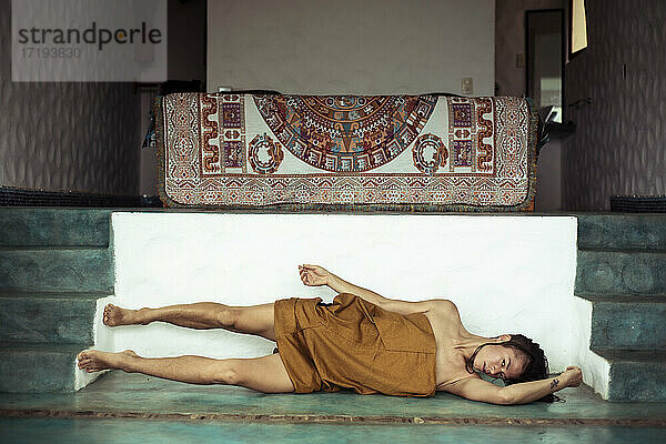 Attraktiver alternativer Mensch tanzt im heiligen Schlafzimmer mit Mayateppich