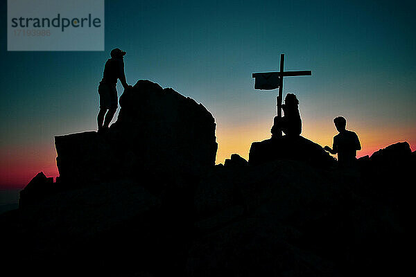 Silhouette einer Gruppe bei Sonnenuntergang auf dem Gipfel der korsischen Berge