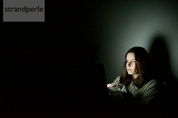 Frau arbeitet nachts am Laptop