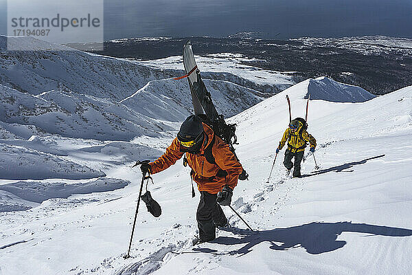 Menschen mit Ski-Splitboarding auf schneebedecktem Berg