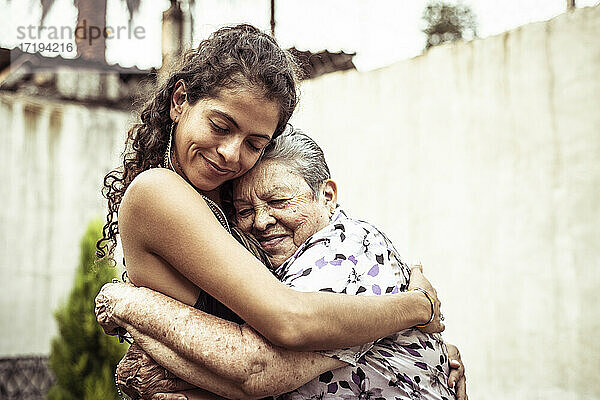 Mexikanische Frauen lächeln in liebevoller Umarmung auf der Sommerstraße in Mecxico