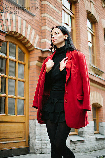 Junger Stil Mode Frau in roter Jacke in der Stadt