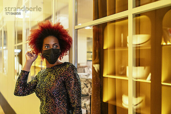 schöne Frau mit Afro-Haar wartet in einem eleganten Kleid