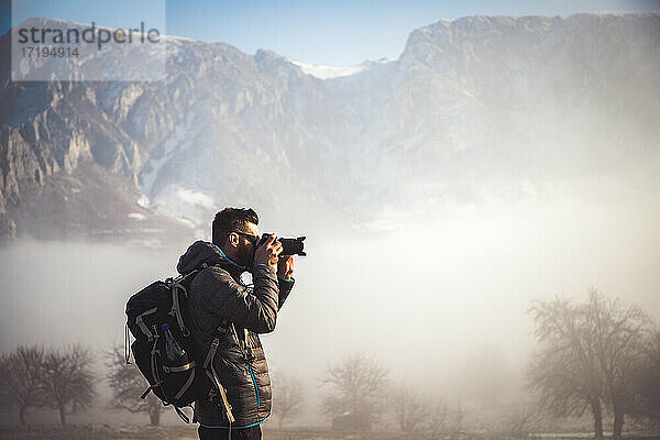 Porträt eines gut aussehenden Mannes beim Trekking in den Bergen im Winter draußen