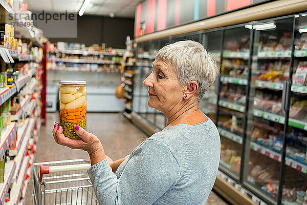 Kaukasische erwachsene Frau mit Gemüsetopf im Supermarkt