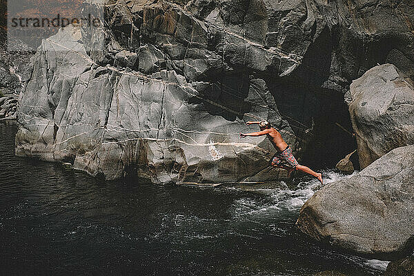 Junge springt in schwimmendes Loch  fließendes Wasser und Granite Canyon Walll