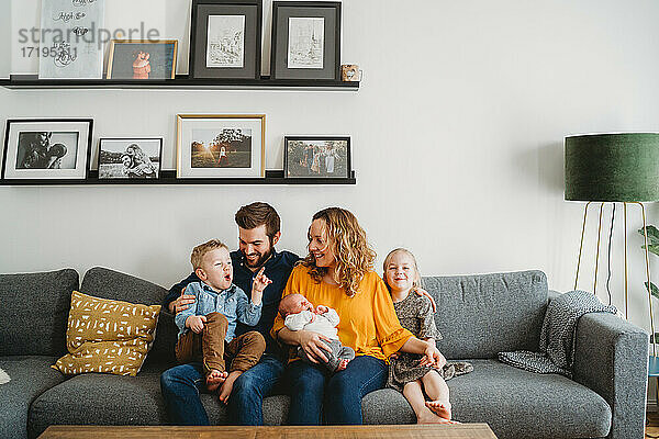 Glückliche weiße Familie auf der Couch in ihrem Wohnzimmer zu Hause