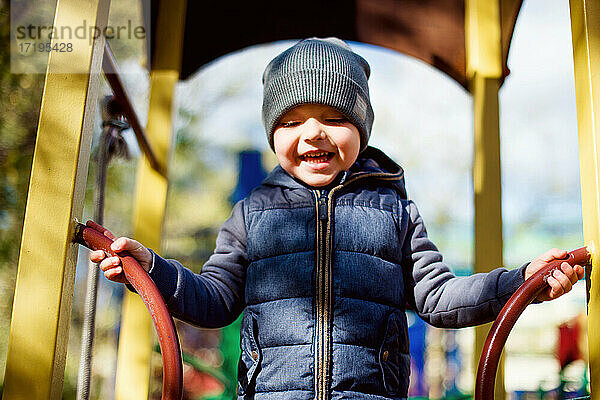 Lachendes glückliches Kind auf dem Spielplatz  Herbstaktivität im Freien