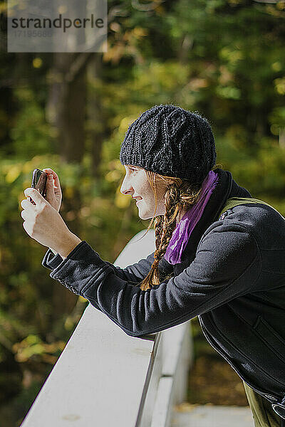 Alleinreisende Frau fotografiert mit ihrem Smartphone