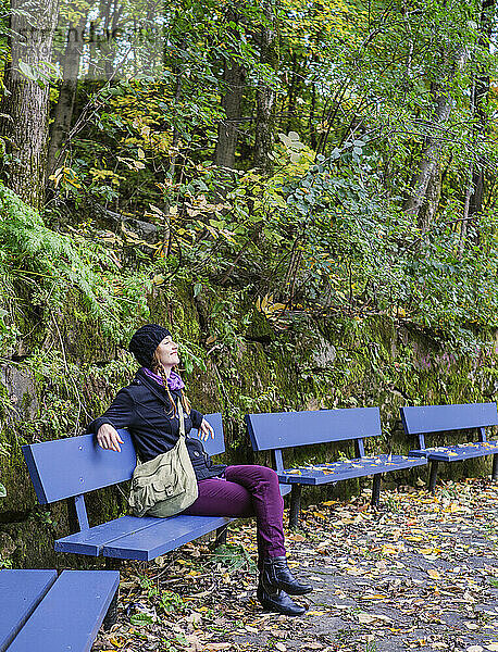 Alleinreisende Frau erkundet Park im Herbst