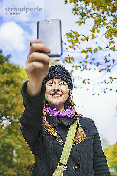 Alleinreisende Frau fotografiert mit ihrem Smartphone