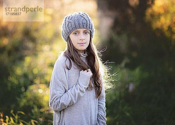 Schönes junges Mädchen in Pullover und Hut im Freien im Herbst.