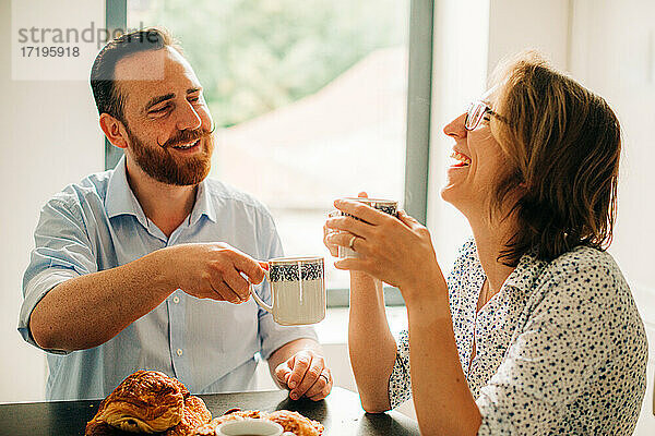 Verheiratetes Paar lächelt und lacht fröhlich beim Frühstück