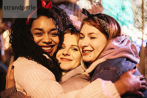 Close up Porträt der glücklichen weiblichen Freunde umarmen in der Stadt bei Nacht
