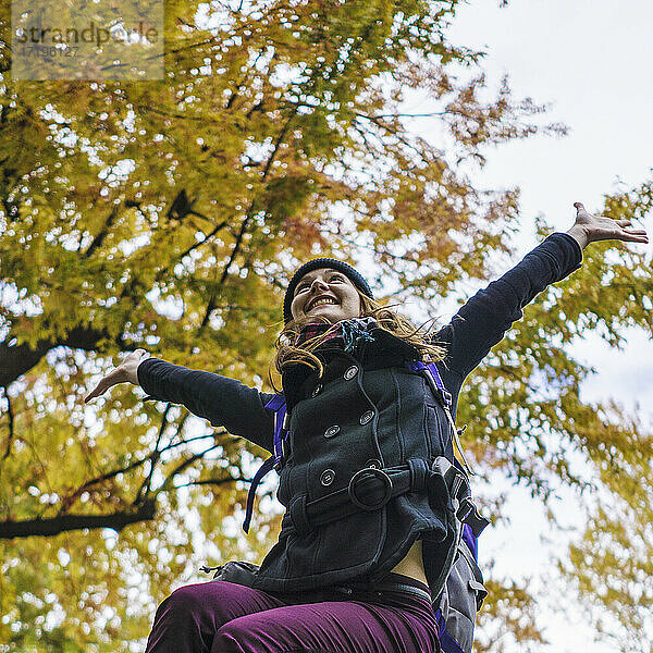 Alleinreisende Frau erkundet Park im Herbst