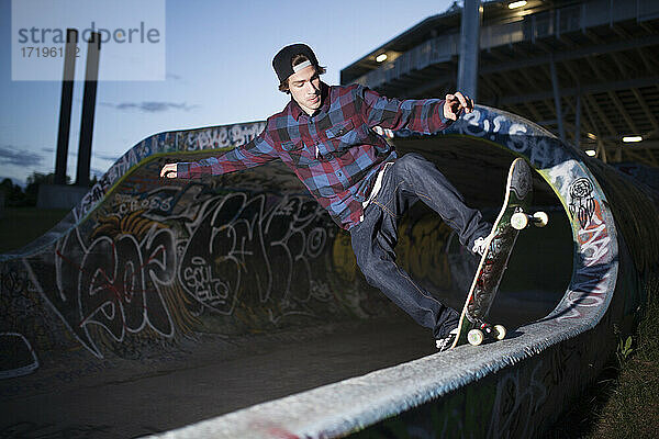 Skateboarder  der nachts auf einer Rampe skatet