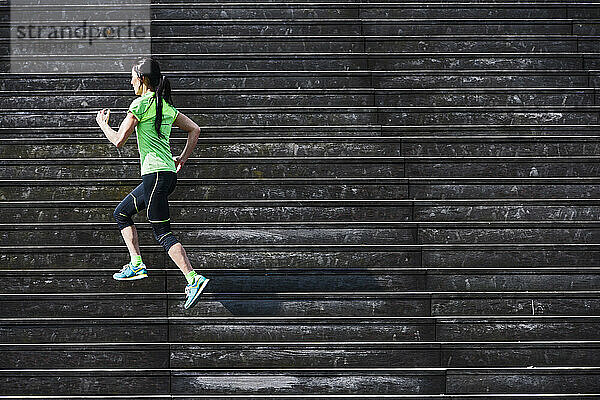 Frau läuft Holztreppe in Paris hinauf