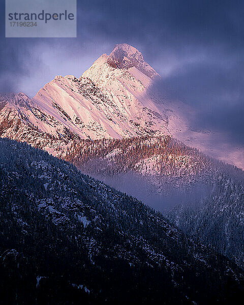 Landschaftlicher Blick auf schneebedeckten Berg gegen bewölkten Himmel bei Sonnenuntergang