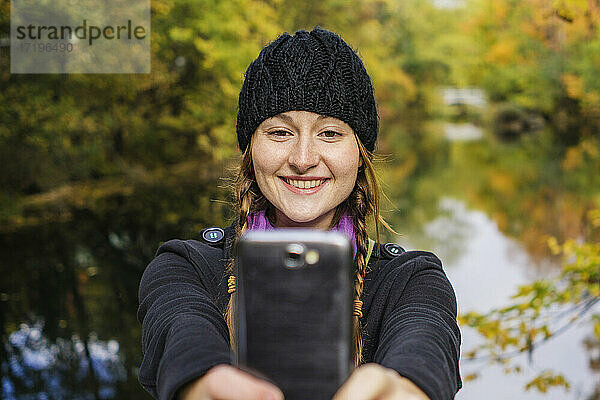 Alleinreisende Frau fotografiert mit ihrem Smartphone