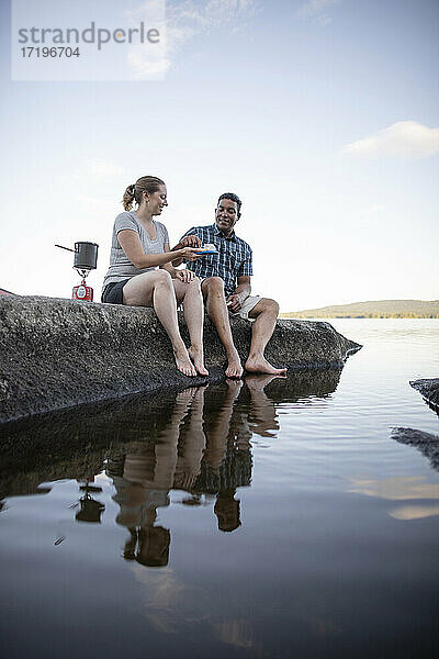 Ein Paar kocht und isst und taucht die Zehen in den See  Bald Mountain Pond  Maine