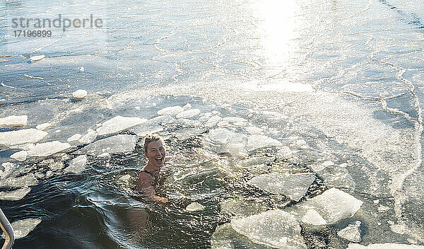 Glückliche Frau Treading Wasser mit Eis im Ozean in Dänemark