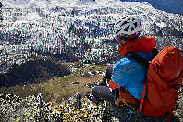 Ein Mann besteigt an einem sonnigen Tag einen verschneiten Berg in Devero  Italien.