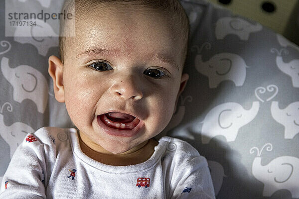 glückliches kleines Baby mit ersten Zähnen  das lächelt und in die Kamera schaut