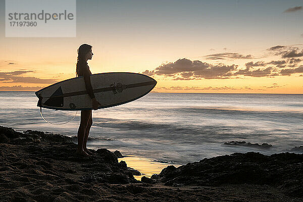 Surfer Girl Silhouette gegen bunte Sonnenuntergang