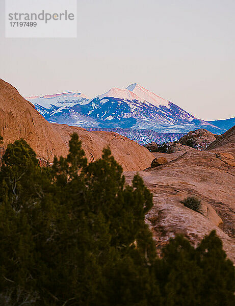 Wüste Berglandschaft bei Sonnenuntergang mit lila und orangefarbenen Tönen