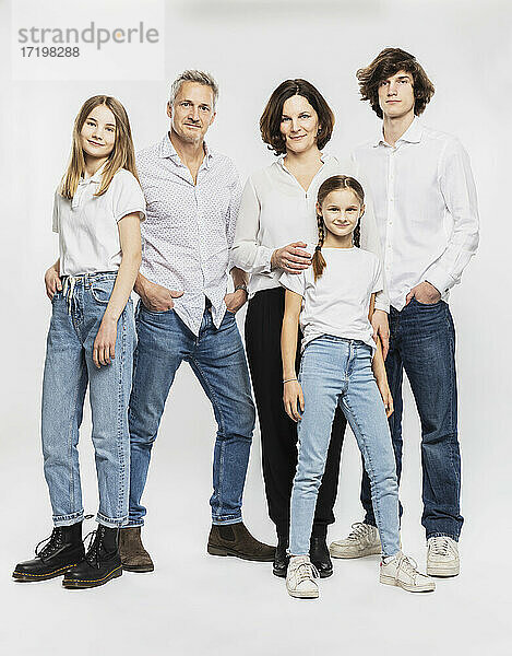 Glückliche Familie mit Kindern  die vor einem weißen Hintergrund stehen
