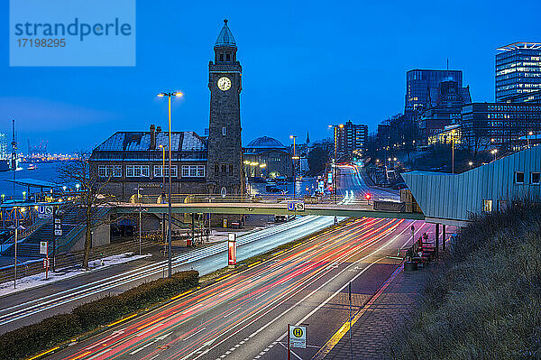 Deutschland  Hamburg  Fahrzeug-Lichtspuren vor dem Uhrenturm der St. Pauli Piers in der Morgendämmerung