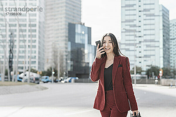 Geschäftsfrau  die beim Gehen in der Stadt mit ihrem Smartphone telefoniert