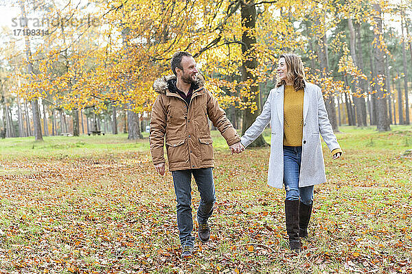 Paar hält Hände beim Spaziergang im Wald